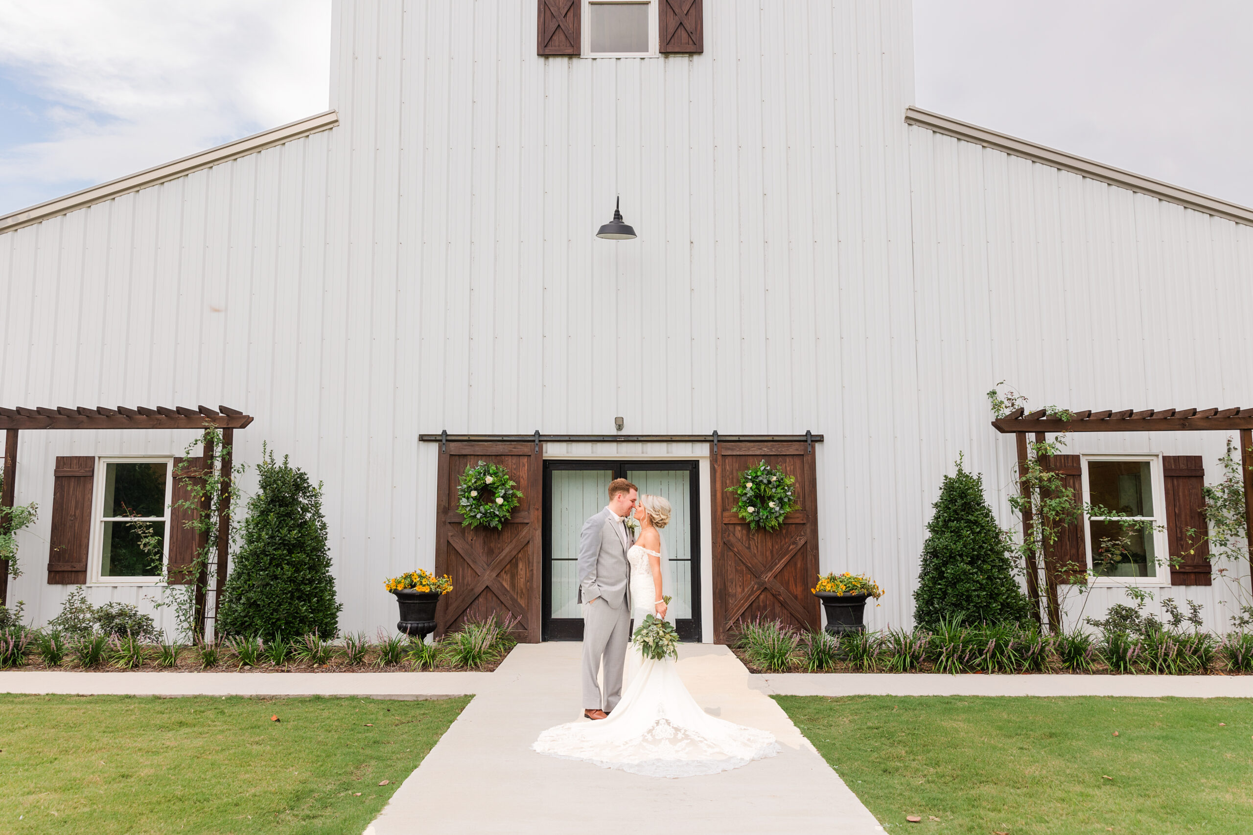 bride and groom posing in front of belles venue and farms in jefferson, sc