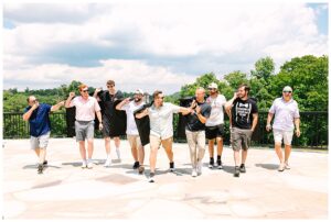 Groom and groomsmen walking together outdoors, looking happy and casual.