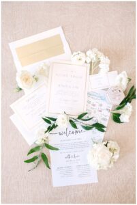 Elegant wedding invitations and details flat lay with white flowers at Vanlandingham Estate, Charlotte, NC.