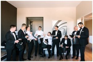 Alt Text: Groomsmen share a lighthearted moment while getting ready at Vanlandingham Estate, Charlotte, NC.