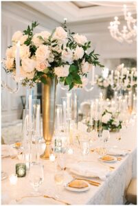 Lavish floral centerpiece on a candlelit dining table.